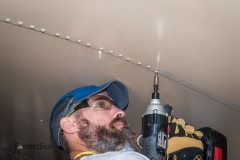 Scott removing rivets from the ceiling using a cordless impact d
